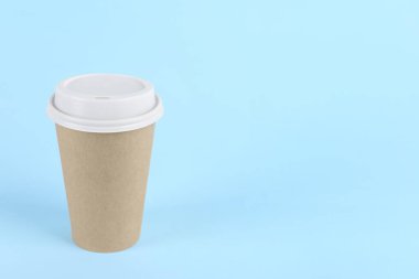 Açık mavi arka planda plastik kapaklı kağıt bardak, metin için boşluk. Kahve hazır.