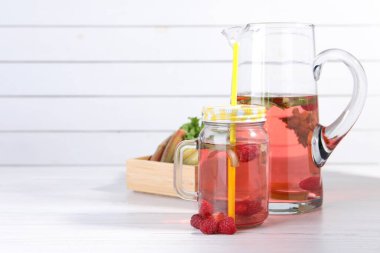 Mason kavanozu ve ahududulu lezzetli ravent kokteyli beyaz ahşap masada, mesaj için yer var.