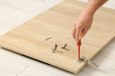 Tornavidalı bir adam mobilyaları topluyor, yakın plan.