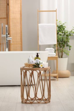 Spa ürünleri, yanan mumlar ve banyo masasında küçük bir çiçek.