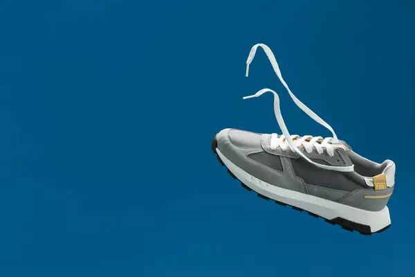 Maviye Karşı Havada Şık Bir Gri Spor Ayakkabı Metin Için — Stok fotoğraf