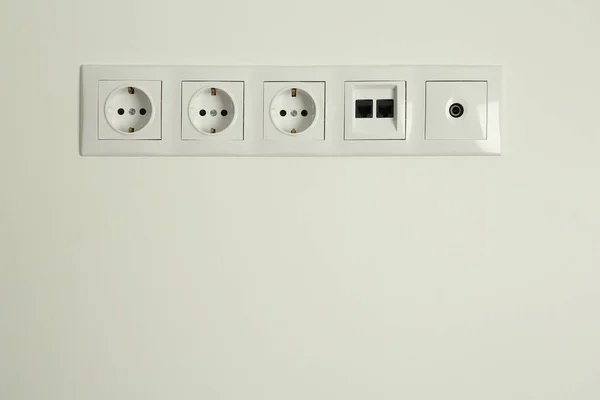 许多电源插座在室内白墙上装有以太网和电视同轴板 案文的篇幅 — 图库照片
