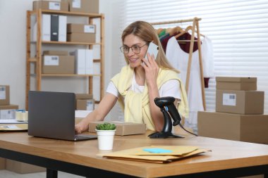 Satıcı ofiste çalışırken telefonla konuşuyor. Çevrimiçi mağaza