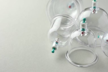 Açık gri arkaplanda plastik bardaklar, metin için boşluk ile yakın çekim. Fincan terapisi.