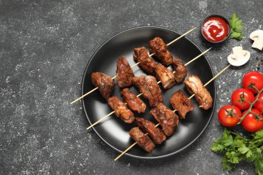 Gri desenli masada servis edilen lezzetli şiş kebaplar.