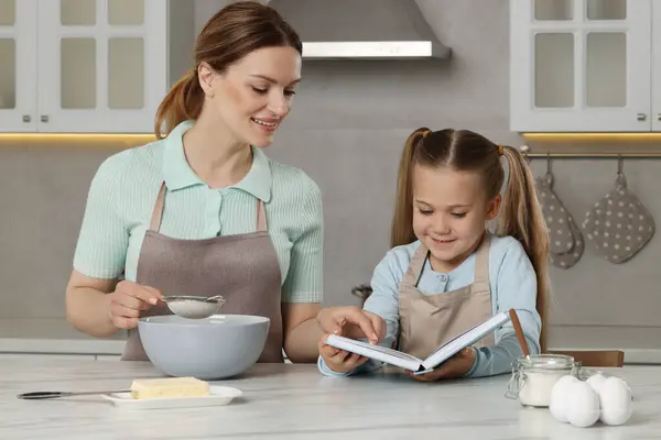 Schattig Klein Meisje Met Haar Moeder Koken Door Recept Boek — Stockfoto