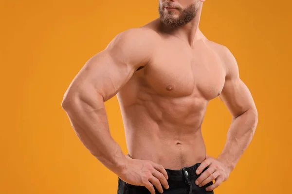 Muskularny Mężczyzna Pokazuje Mięśnie Pomarańczowym Tle Zbliżenie Sexy Ciało — Zdjęcie stockowe