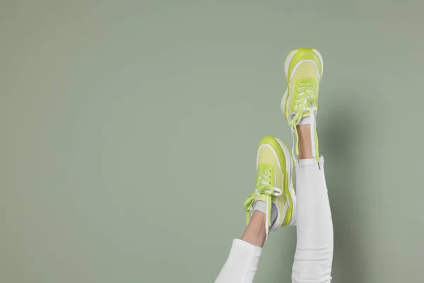 Kvinna Bär Par Nya Snygga Sneakers Ljusgrön Bakgrund Närbild Plats — Stockfoto