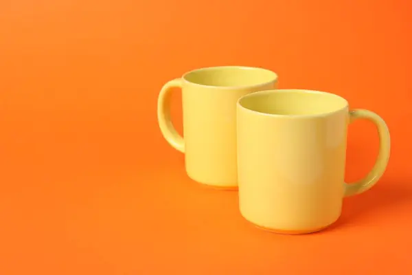 Дві Жовті Керамічні Чашки Помаранчевому Фоні Простір Тексту — стокове фото