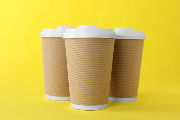 Sarı Arka Planda Beyaz Kapaklı Kağıt Bardaklar Kahve Hazır — Stok fotoğraf