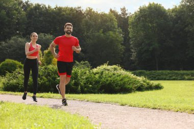 Sağlıklı bir yaşam tarzı. Güneşli bir günde dışarıda koşan mutlu çift, mesaj için yer var.