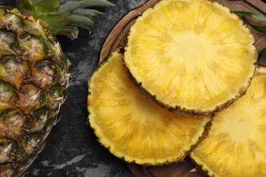 Lezzetli olgun ananas dilimleri siyah desenli masa, düz uzanmış