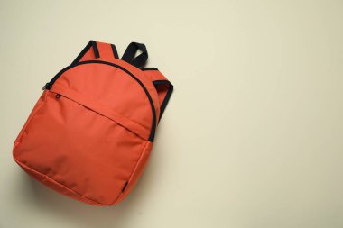Açık arkaplanda turuncu bir sırt çantası, üst manzara. Metin için boşluk