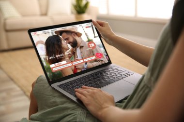 Ortak arıyorum. Evde dizüstü bilgisayar kullanan bir kadın, yakın çekim. Aygıt ekranındaki randevu sitesi web sayfası