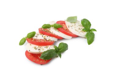 Beyaz arka planda mozarella, domates, fesleğen ve baharatlı Caprese salatası.