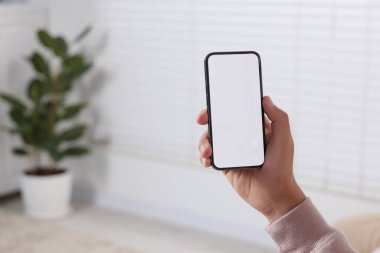 Modern cep telefonunu kapalı mekanda kullanan adam, yakın plan. Metin için boşluk