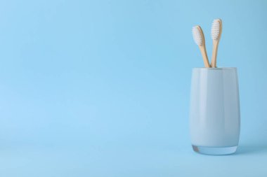 Açık mavi arkaplanda Bambu diş fırçaları, metin için boşluk