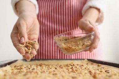 Lezzetli baklava yapıyorum. Kadın hamura fındık ekliyor, yakın plan.