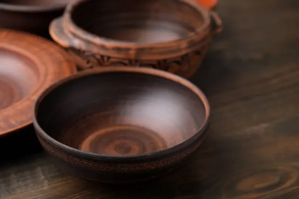 Set of clay dishes on wooden table, closeup. Cooking utensils