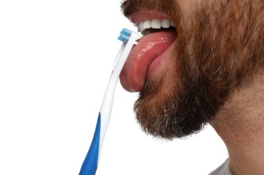 Beyaz arka planda dilini temizleyen adam, yakın plan.