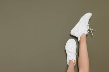 Kadın koyu zeytinli arka planda şık ayakkabılar giyiyor, yakın plan. Metin için boşluk