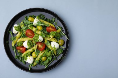 Açık gri masada nefis pesto makarna salatası, üst manzara. Metin için boşluk