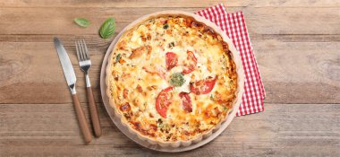 Tahta masada servis edilen domatesli ve peynirli kiş. Pankart tasarımı