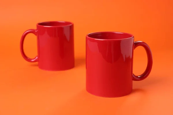 Дві Червоні Керамічні Чашки Помаранчевому Фоні — стокове фото