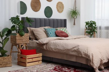 Büyük, rahat bir yatak odası ve şık bir yatak odasında saksı çiçekleri. İç tasarım