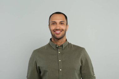 Gri arka plan üzerinde yakışıklı genç adam portresi