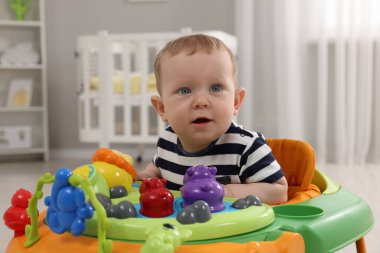 Evde oyuncak yürüteçle sevimli bebek portresi. Yürümeyi öğrenmek.