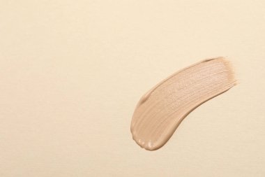 Bej arka planda cilt temeli lekesi, üst manzara. Metin için boşluk