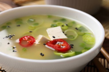 Bir kase lezzetli miso çorbası, masada tofu, yakın plan.