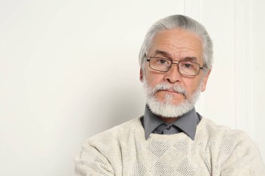 Beyaz duvarın yanında gözlüklü yakışıklı bir adamın portresi. Metin için boşluk