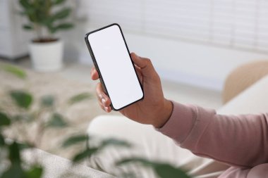 Modern cep telefonunu kapalı mekanda kullanan adam, yakın plan.