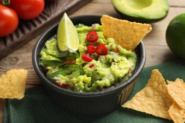 Tahta masada cips ile servis edilen nefis guacamole, yakın plan.