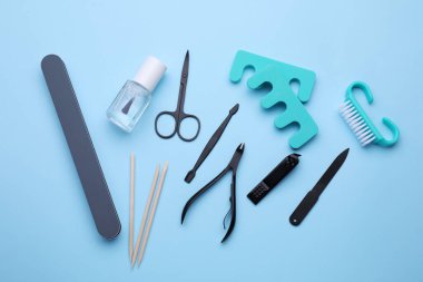 Açık mavi arkaplan üzerinde pedikür araçları kümesi, düz yatıyordu