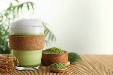 Cam bardak taze kibrit latte, pudra ve bambu çırpıcı. Metin için boşluk