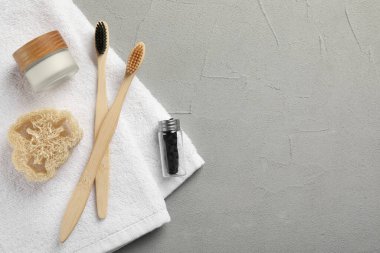Açık gri masada bambu diş fırçaları ile düz bir kompozisyon vardı. Metin için boşluk