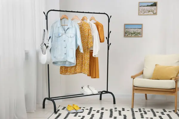 Stylish showroom interior with clothing rack and armchair