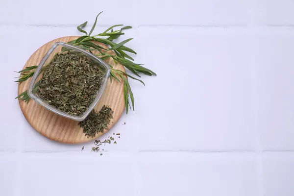 Dry and fresh tarragon on white tiled table, top view. Space for text