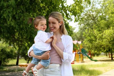 Happy mother with her daughter spending time together in park