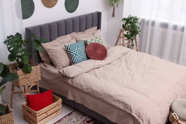 Büyük, rahat bir yatak odası ve şık bir yatak odasında saksı çiçekleri. İç tasarım