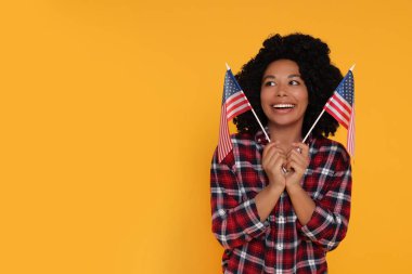 4 Temmuz - ABD 'nin Bağımsızlık Günü. Sarı arka planda Amerikan bayrakları olan mutlu kadın, mesaj için yer