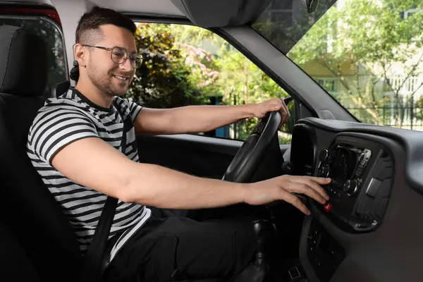 お気に入りのラジオを選択する 車のオーディオのハンサムな男の押すボタン — ストック写真