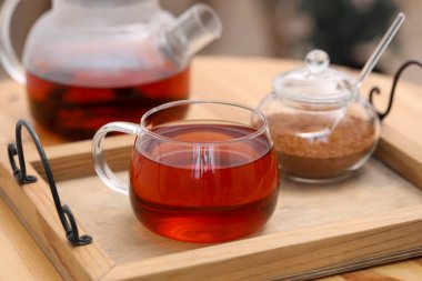 İçerideki masaya bir fincan aromatik çay ve kahverengi şeker.