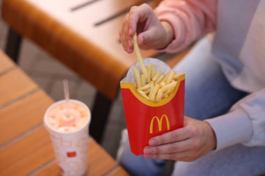Lviv, Ukrayna - 26 Eylül 2023: McDonald 's' ın patateslerini yiyen kadın, yakın plan