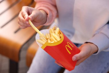 Lviv, Ukrayna - 26 Eylül 2023: McDonald 's' ın patateslerini yiyen kadın, yakın plan