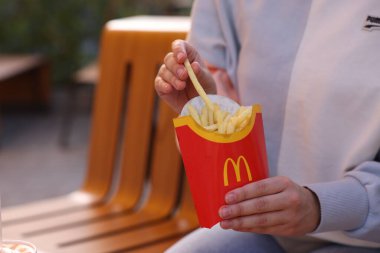 Lviv, Ukrayna - 26 Eylül 2023: McDonald 's' ın patateslerini yiyen kadın, yakın plan