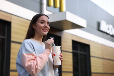 Lviv, Ukrayna - 26 Eylül 2023: McDonald 's açık havada içen kadın, mesaj için yer